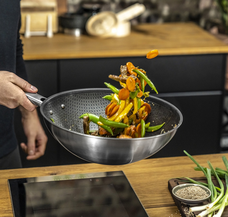 Wokgemüse im Wok wird in die Luft gewirbelt