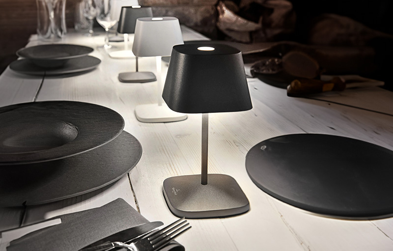 Ein gedeckter Tisch mit einer eingeschalteten Tischlampe