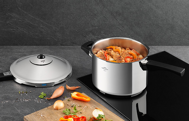 Ein gefüllter Schnellkochtopf steht auf einer Herdplatte