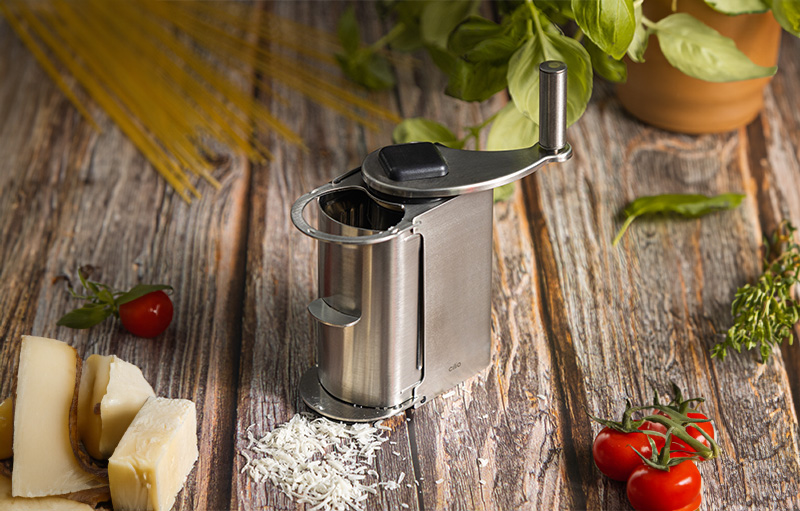 Eine Käsereibe auf einem Holzbrett