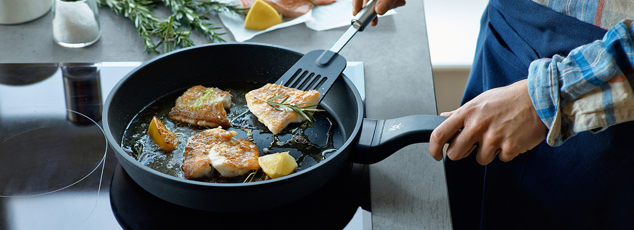 Ein Fischgericht wird in einer Pfanne gebraten