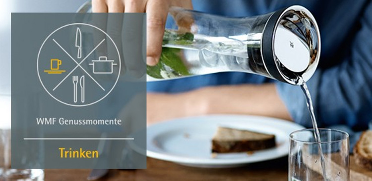 Wasser wird mit einer Wasserkaraffe in ein Glas geschüttet