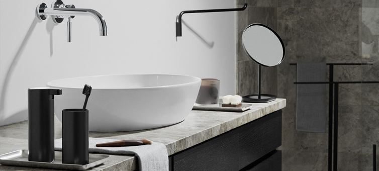 Ein Waschbecken mit Seifenspender und Zahnbürste im Becher